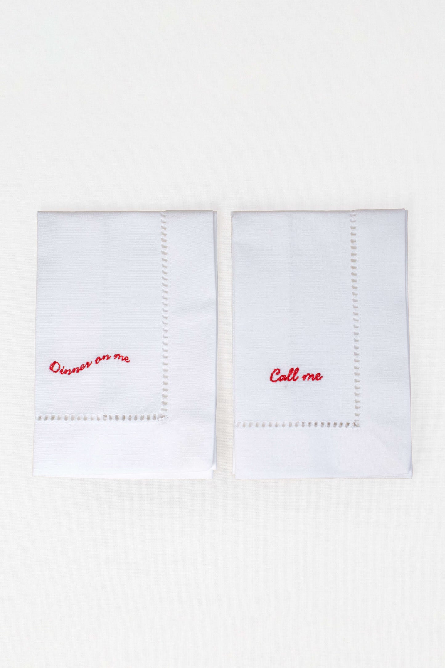 Two white handkerchiefs with red text on a white background