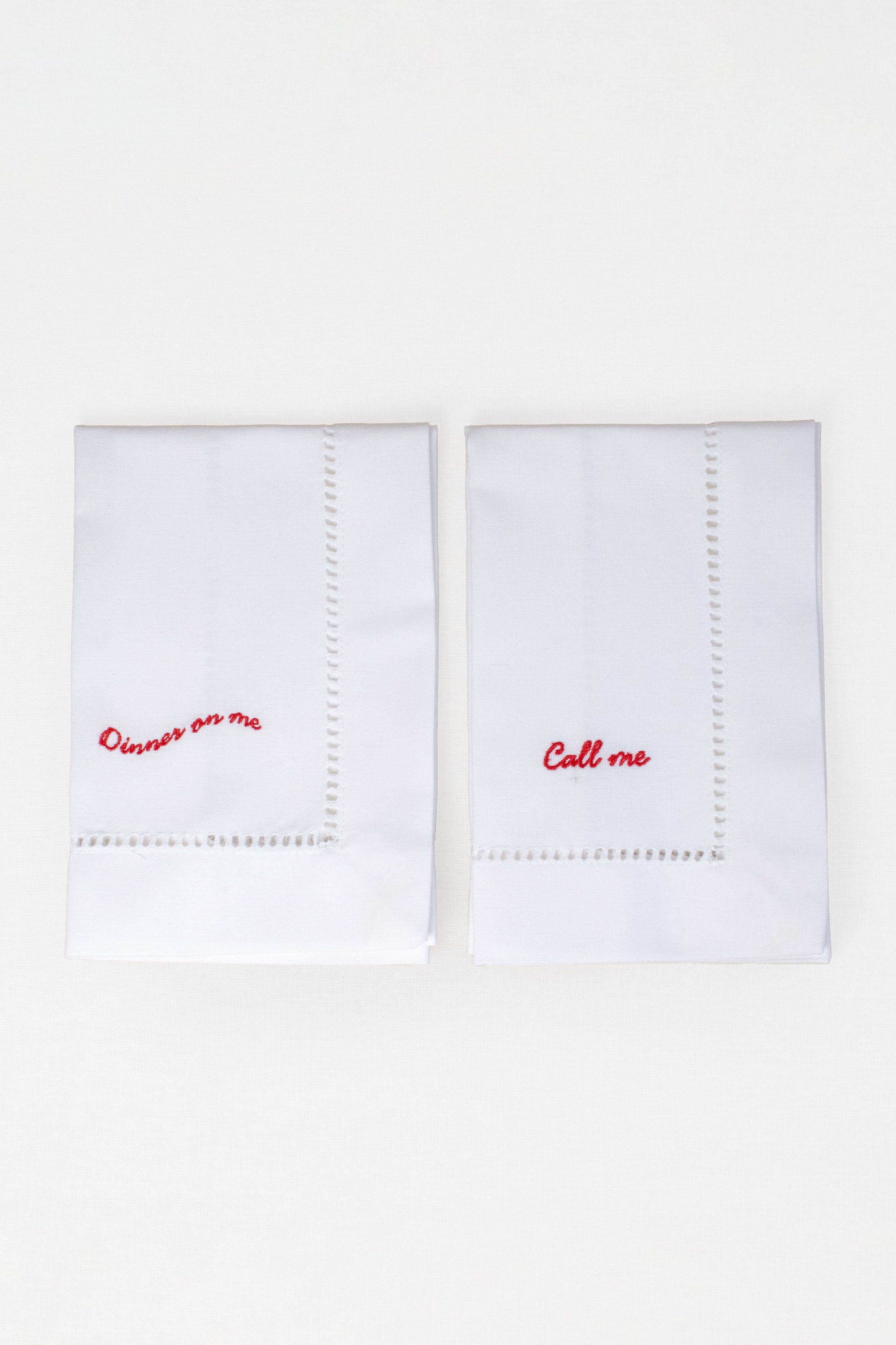 Two white handkerchiefs with red text on a white background